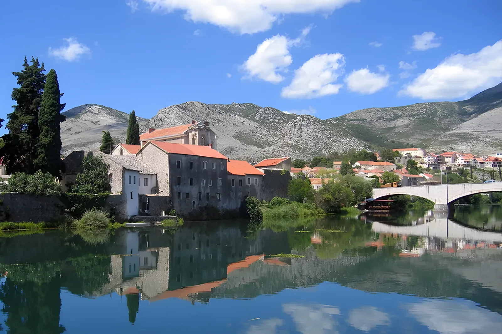 Istorijske kamene zgrade koje se odražavaju u mirnoj vodi reke · Trebinje, Herceg Novi i Dubrovnik - 1 noćenje, Trebinje