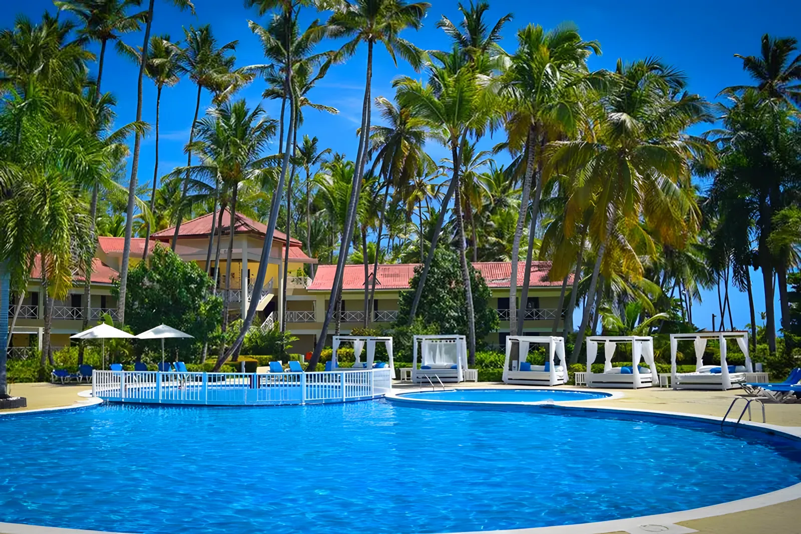 Veliki kružni bazen sa belim kabanama i palmama unaokolo · Vista Sol Punta Cana Beach Resort & Spa Hotel
