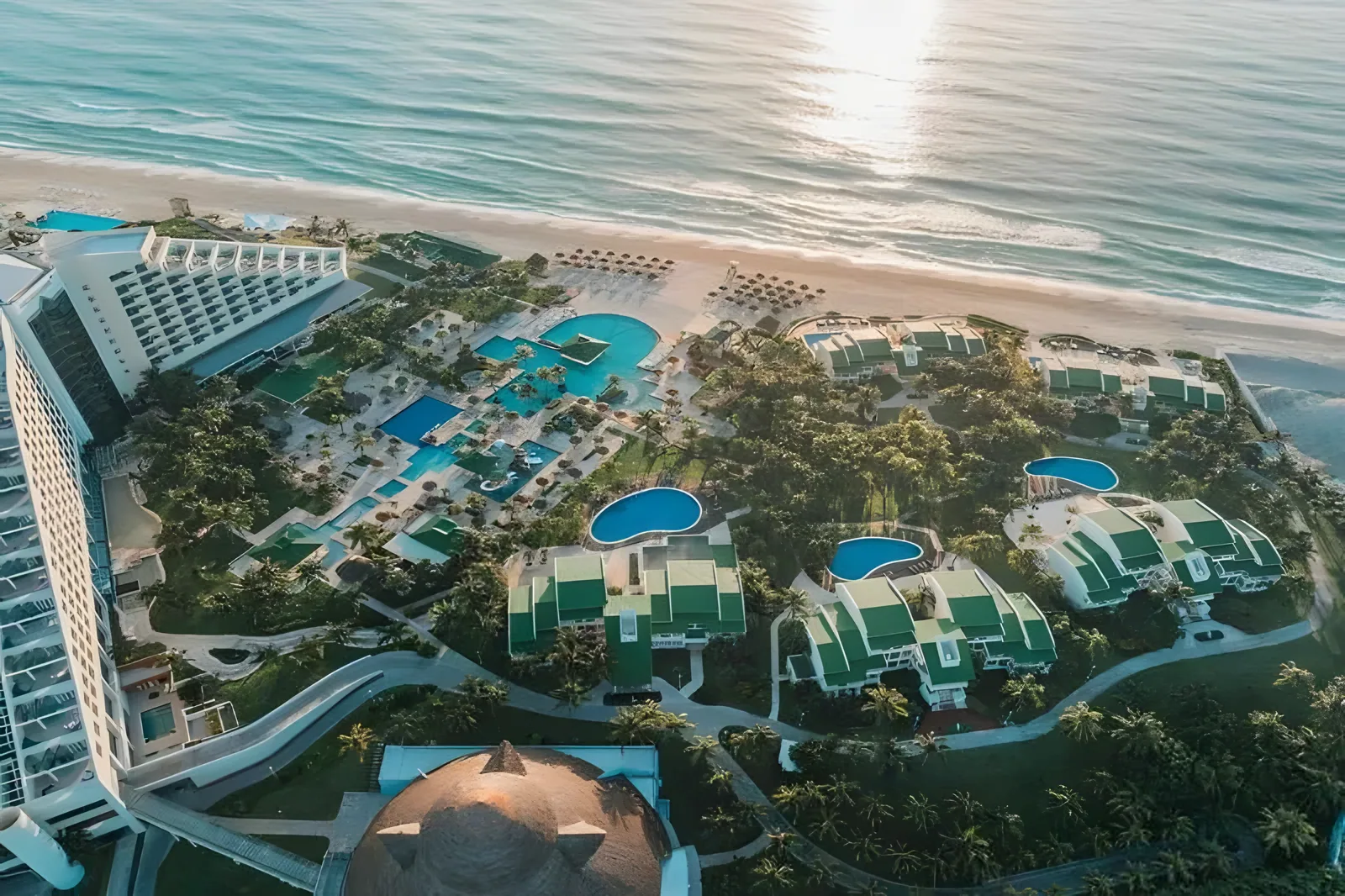 Bazeni letovališta i pristup plaži sa visokom zgradom u blizini · Hotel Iberostar Selection Cancun