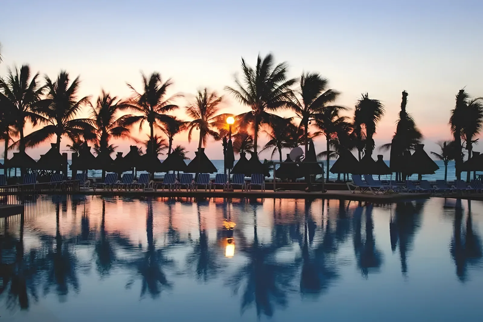 Pogled na bazen i palme koje se ogledaju u vodi u suton · Viva Wyndham Maya Hotel 4*, Playa del Carmen