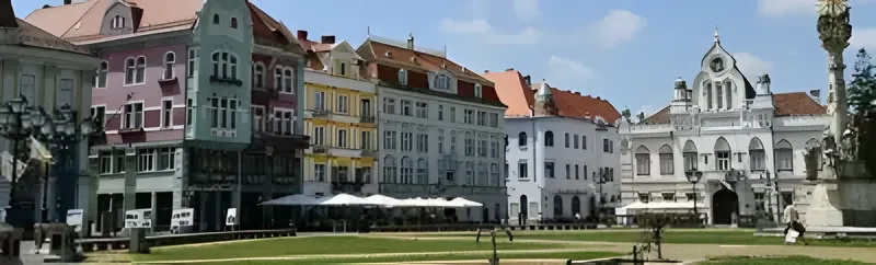 Istorijski gradski trg sa pastelnim zgradama i zelenom travom · Temišvar i Arad - 1 noćenje, Temišvar