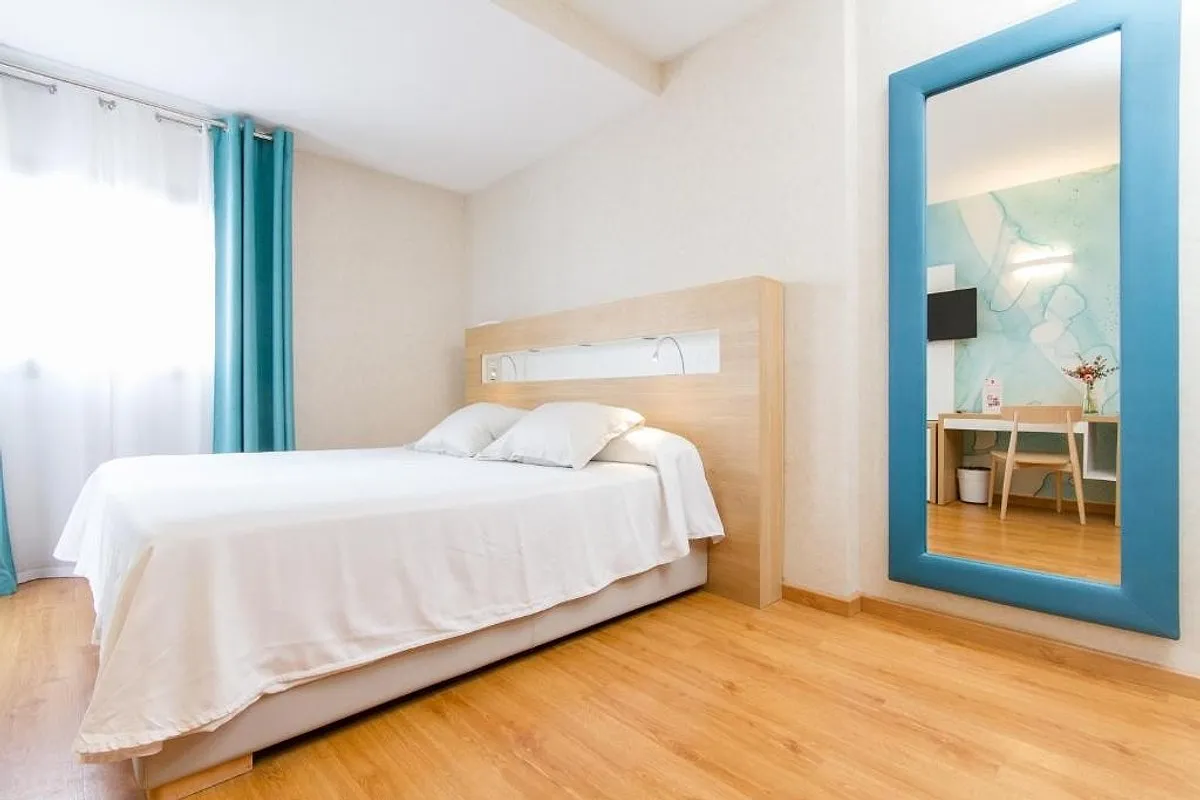 Soba sa bračnim krevetom i velikim ogledalom u tirkiznom ramu · Hotel Castilla Alicante, Alikante