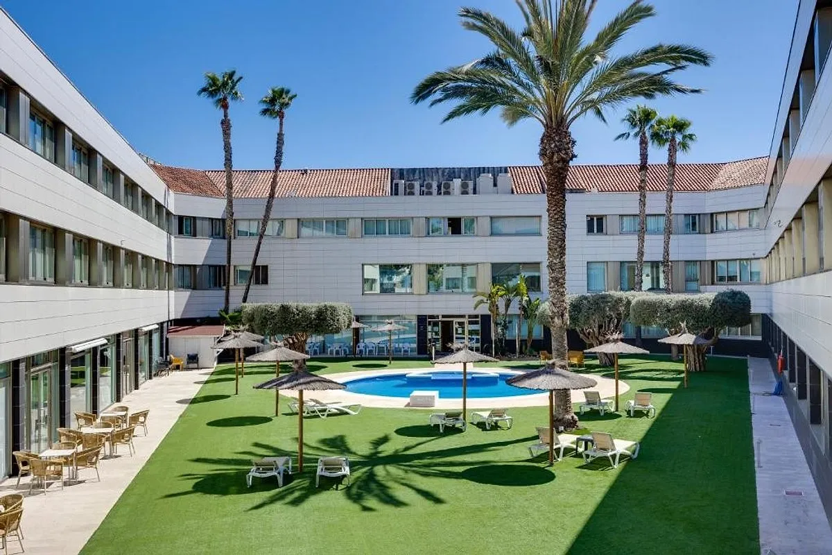 Dvorište hotela sa bazenom, palmama i suncobranima · Hotel Daniya Alicante, Alikante