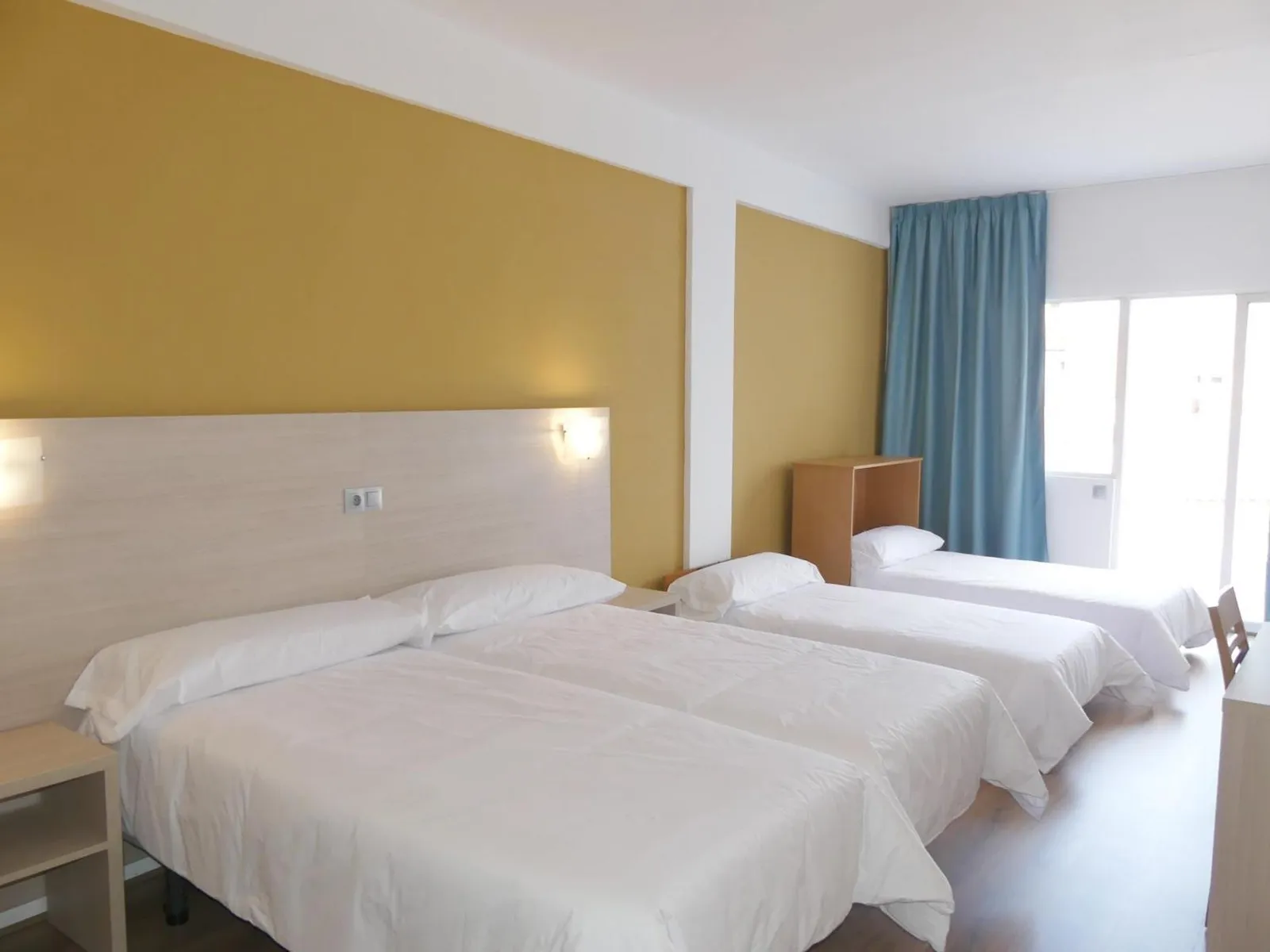 Soba sa više odvojenih kreveta i žutim zidom · Hotel Benidorm City Olympia, Benidorm