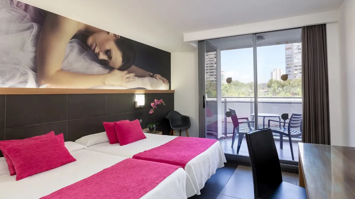 Soba sa bračnim krevetom sa ružičastim detaljima i izlazom na balkon · Hotel Flash Benidorm, Benidorm