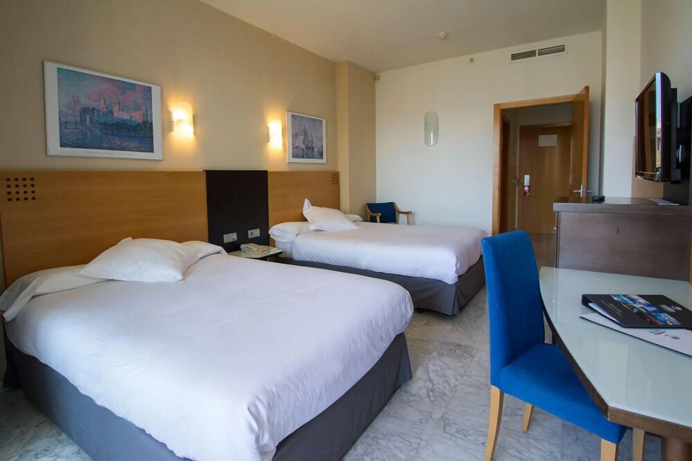 Soba sa dva kreveta, radnim stolom i plavom stolicom · Hotel Madeira Centro, Benidorm