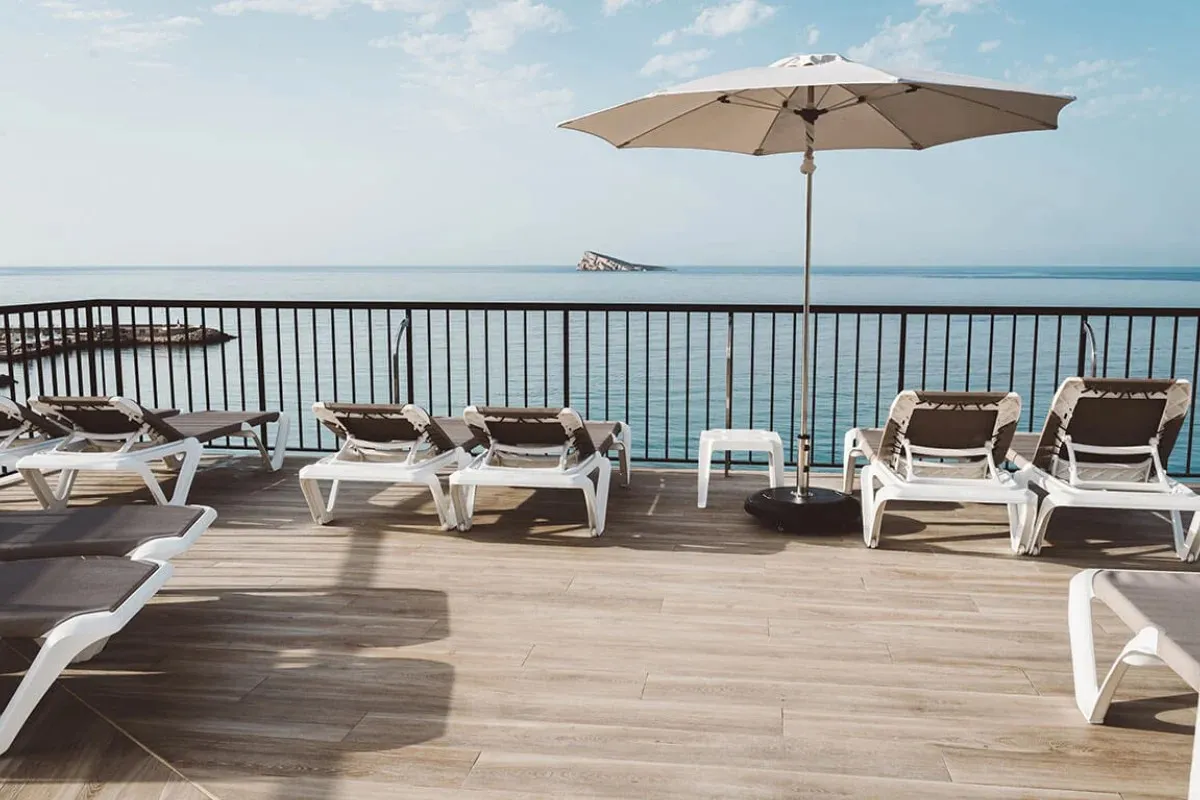 Krovna terasa sa ležaljkama, suncobranom i morem u pozadini · Hotel Marconi, Benidorm