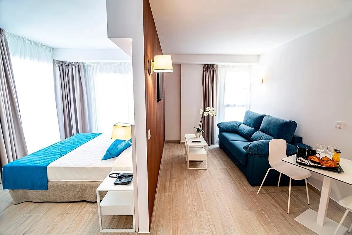 Svetla soba sa krevetom i plavom sofom · Hotel Rosamar, Benidorm