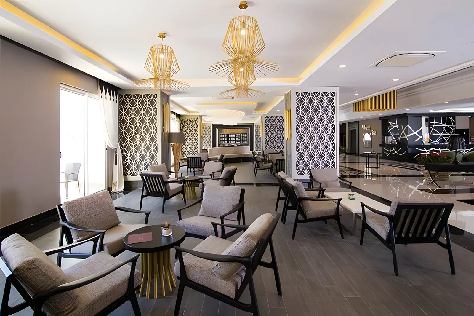 Elegantan prostor za odmor sa zlatnim privesnim svetlima i tapaciranim sedištima · Port River and Spa Hotel, Side